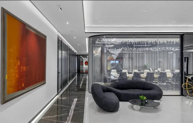 Executive suite with red artwork, curved sofas and glass partitions