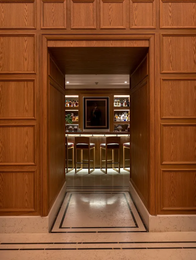 Timber doorway opening onto an illuminated bar