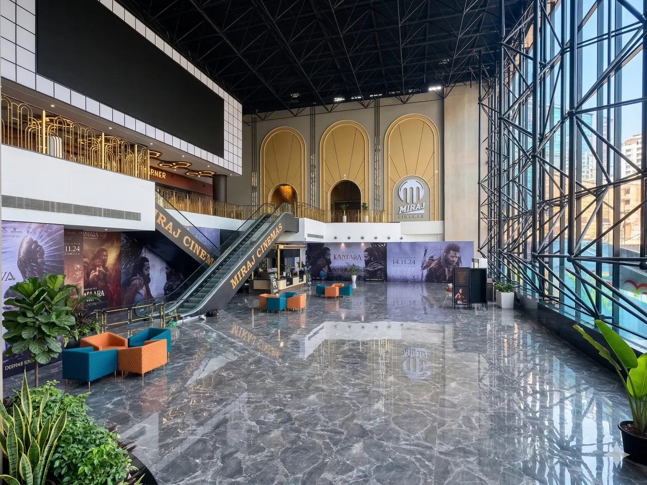 Cinema lobby with arched golden facade, escalator and polished stone floor