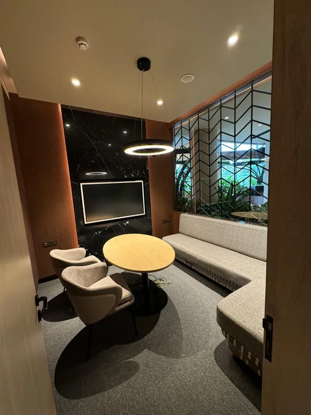 Dark-toned meeting nook with sculpted seating