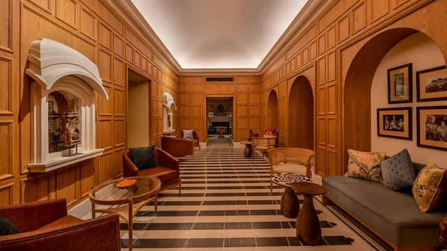 Timber-panelled gallery with arched niches and a patterned stone floor